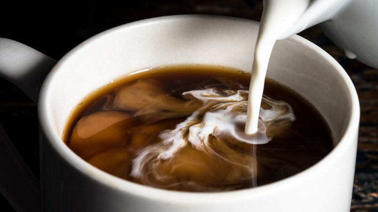 milk poured into cup of coffee