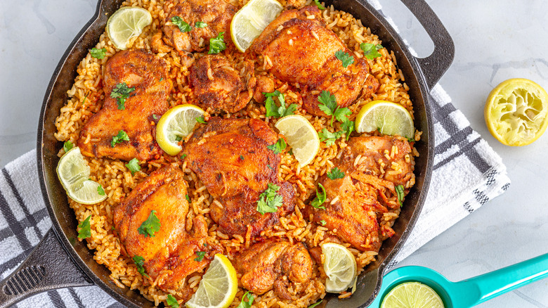 chicken and rice in a skillet with lemon slices