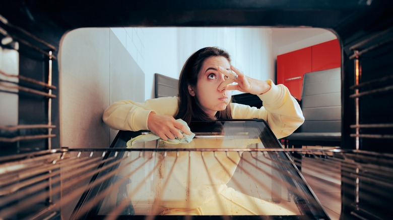 Person cleaning smelly oven