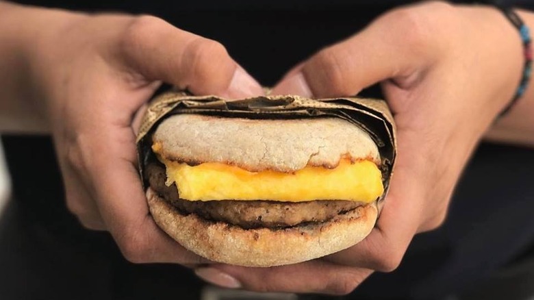 English muffin and egg sandwich in hands