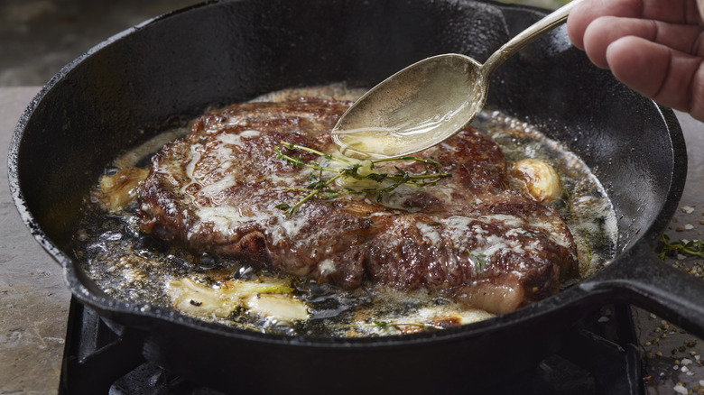 Butter basting steak in a pan