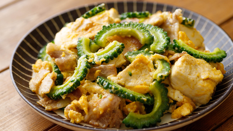 Bowl of goya champloo with large chunks of tofu and goya