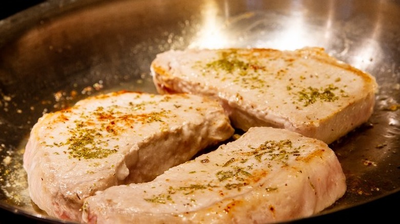 Pork chops searing in pan