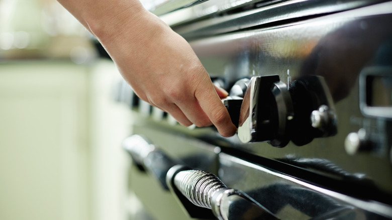 person turning up oven