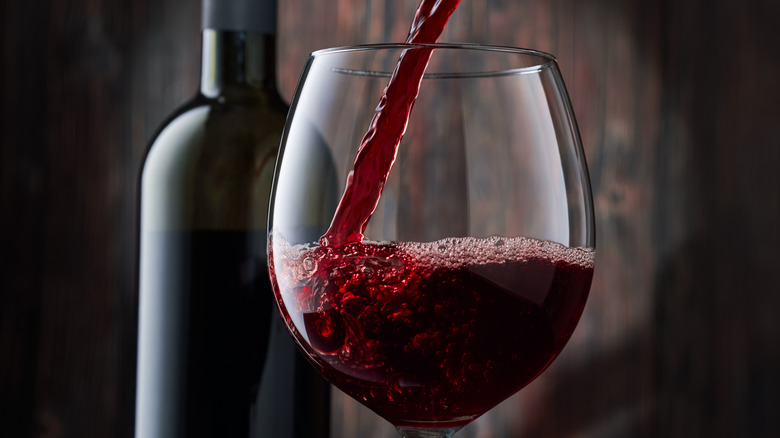 pouring red wine into glass