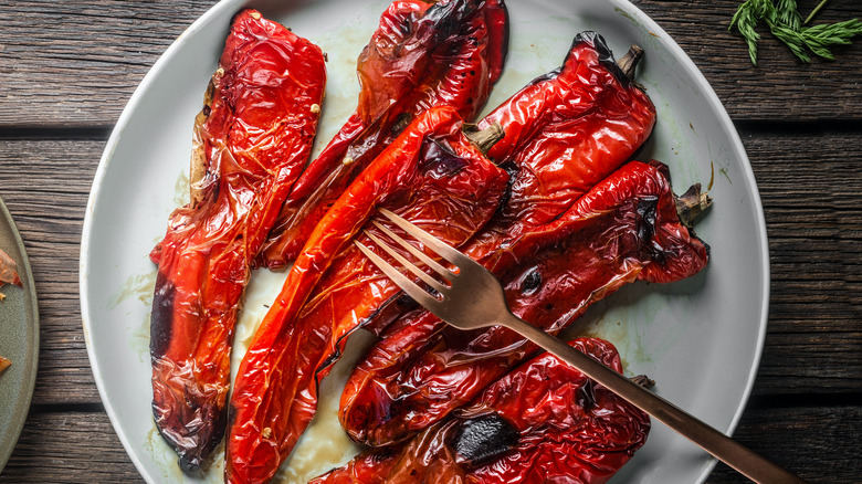 Plate of grilled, lightly charred red peppers.