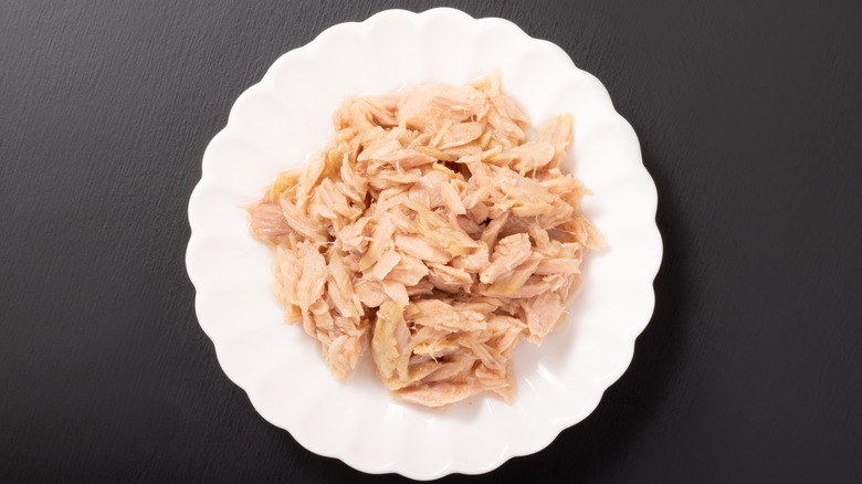 White plate of canned chicken chunks