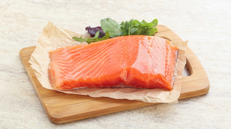 raw salmon filet on cutting board