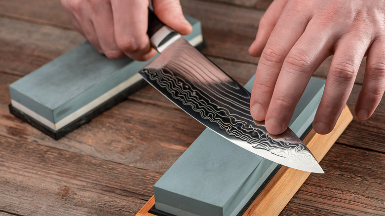 Knife being sharpened on stone