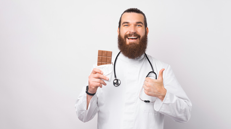 Doctor holding up a chocolate bar