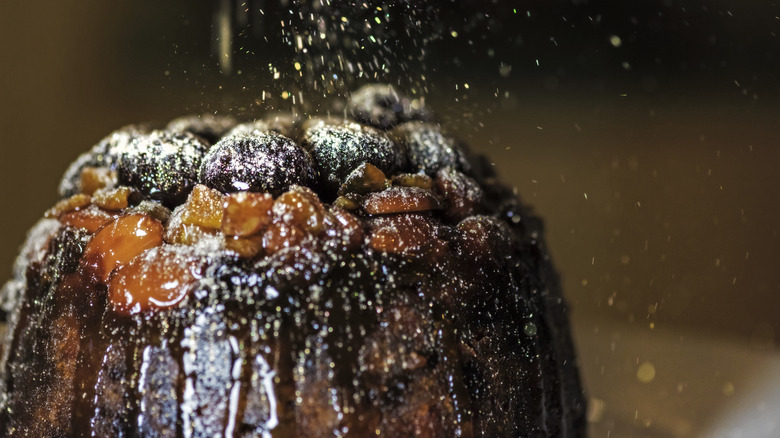 glazed fruit crowning a black cake