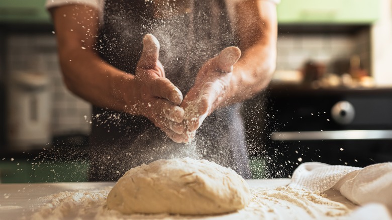 chef dusting flour on dough