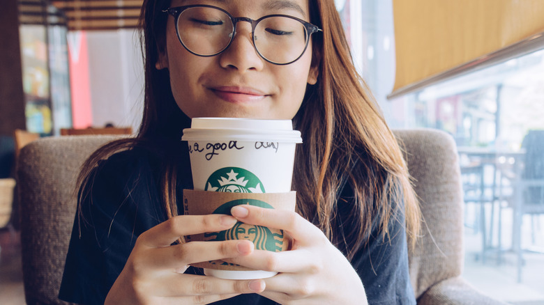 Woman smiling with Starbucks coffee