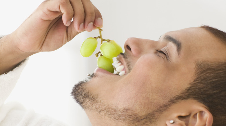 man eating grapes