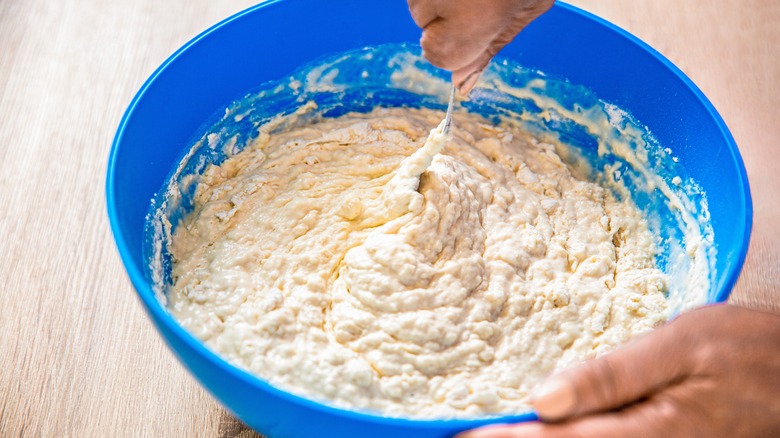 hands mixing bowl of dough