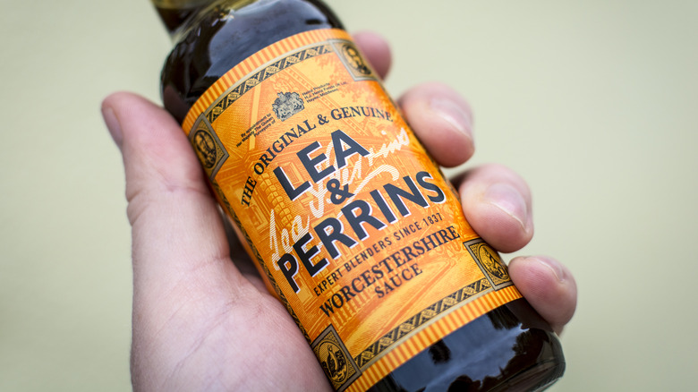 Person holding Worcestershire sauce bottle