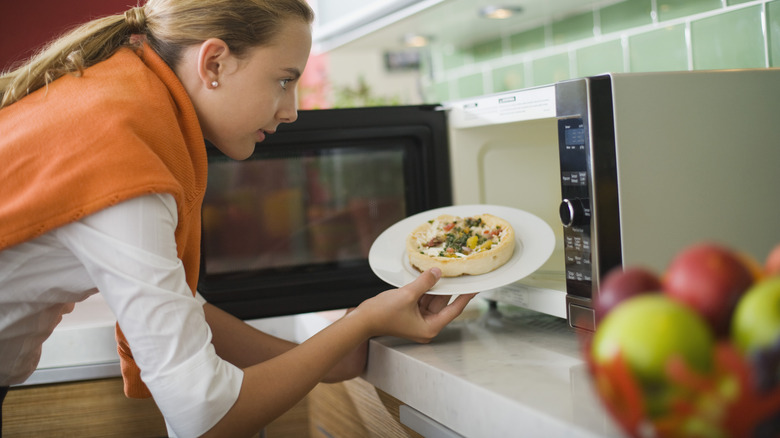 Woman using microwave