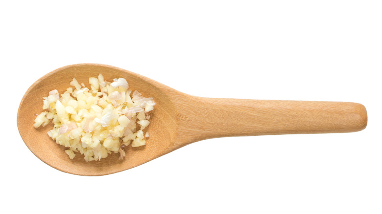 Wooden spoon with chopped garlic