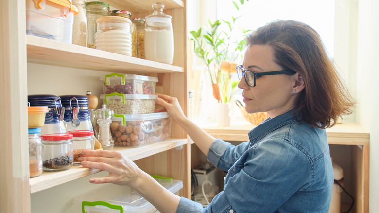 Woman looking through kitchen pantry