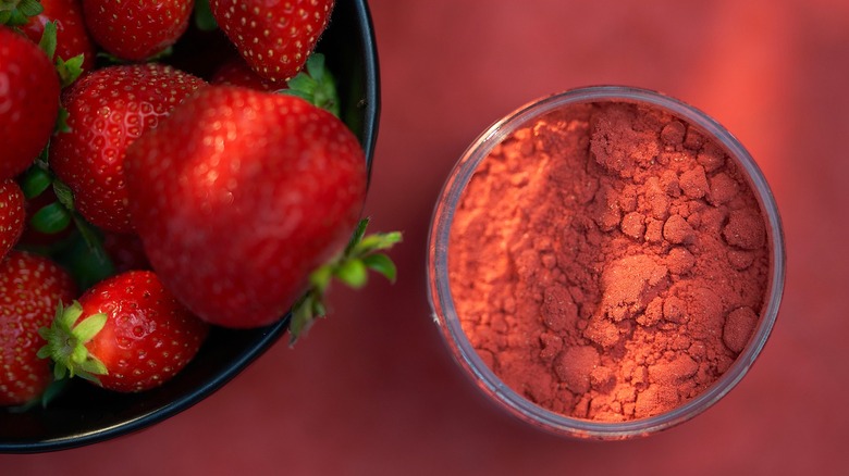 a bowl of strawberries and a bowl of freeze-dried strawberry powder