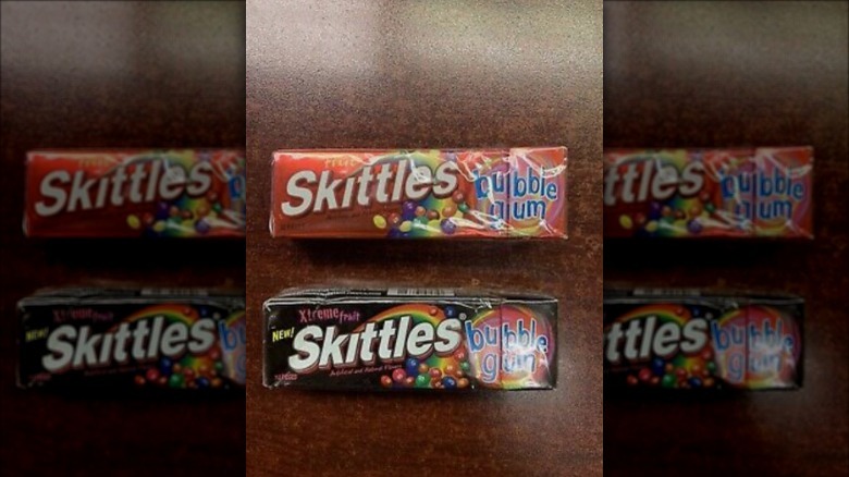 a pack of skittles bubble gum and skittles xtreme fruit gum on a brown table