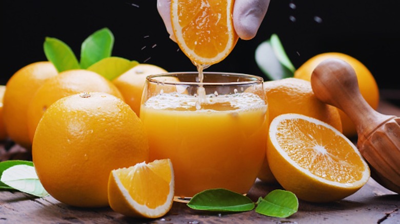 squeezing orange juice into glass