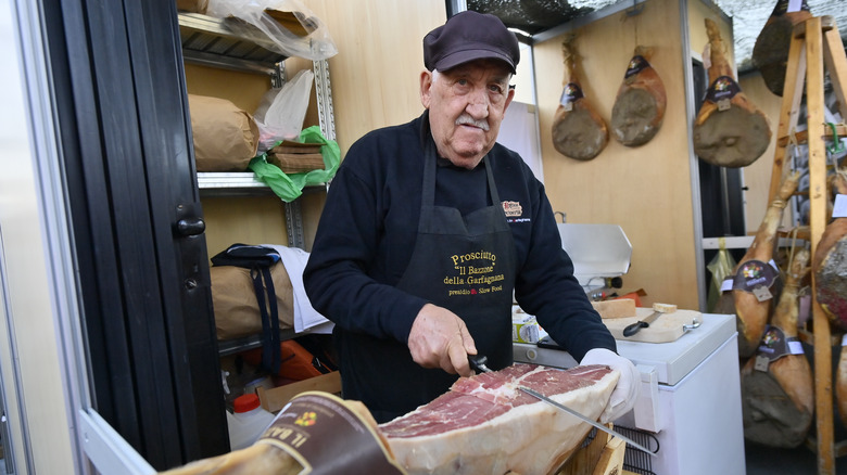 Man carving dry-cured ham