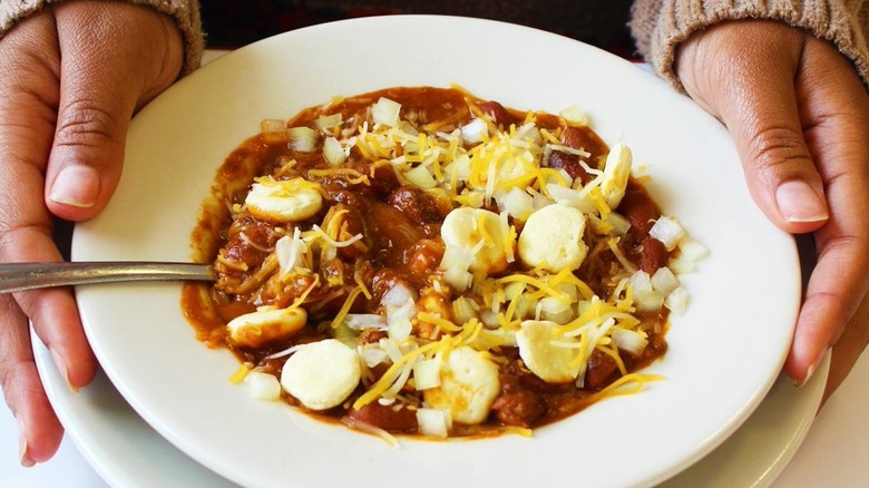 Hands holding bowl of chili