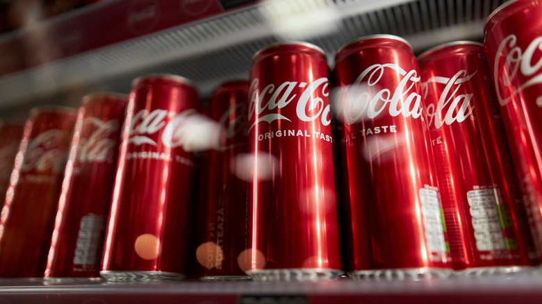 Coca-Cola cans on a shelf