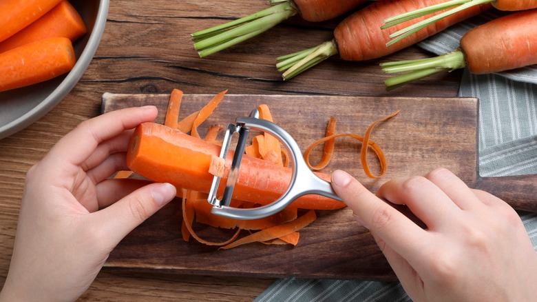 Hands peeling a carrot