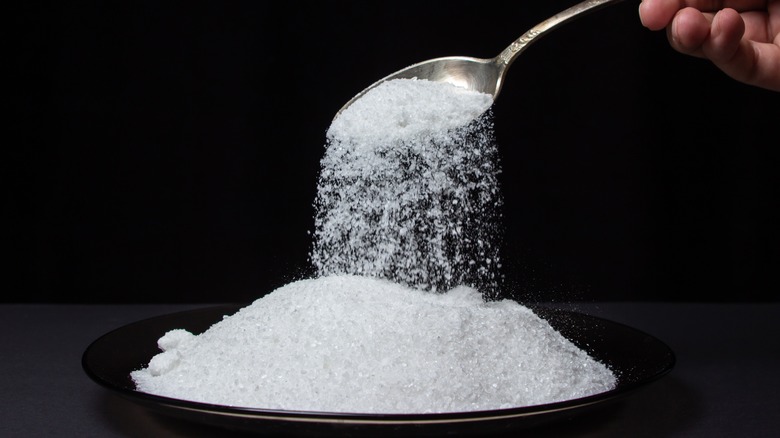 Pouring table salt from a spoon