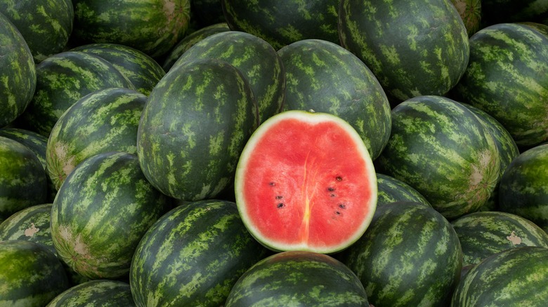 large watermelon pile with one sliced open