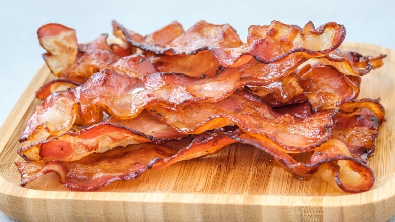 Fried bacon on wooden platter