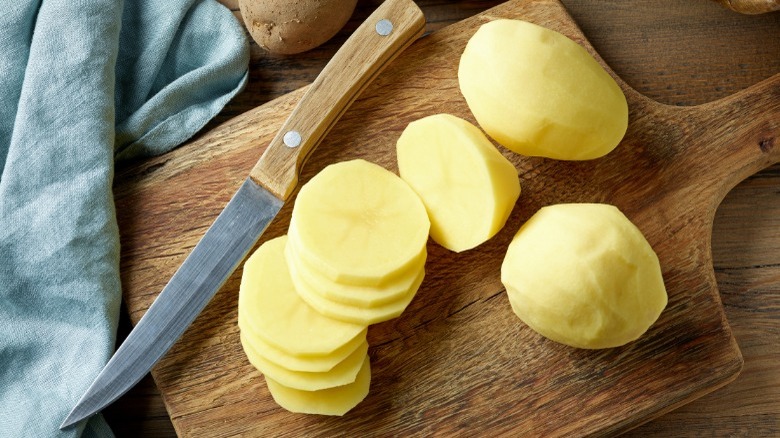 Sliced potatoes on cutting board