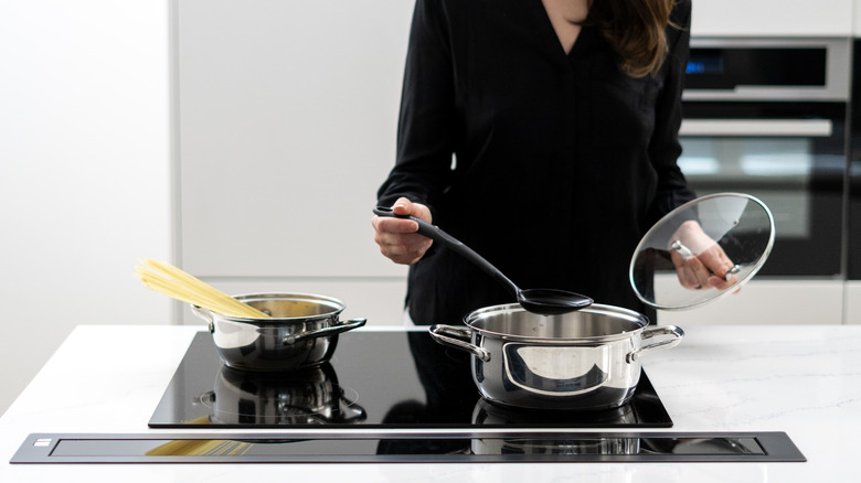 Person cooking on induction cooktop