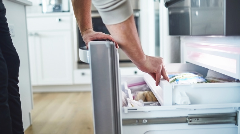 Person opening freezer drawer