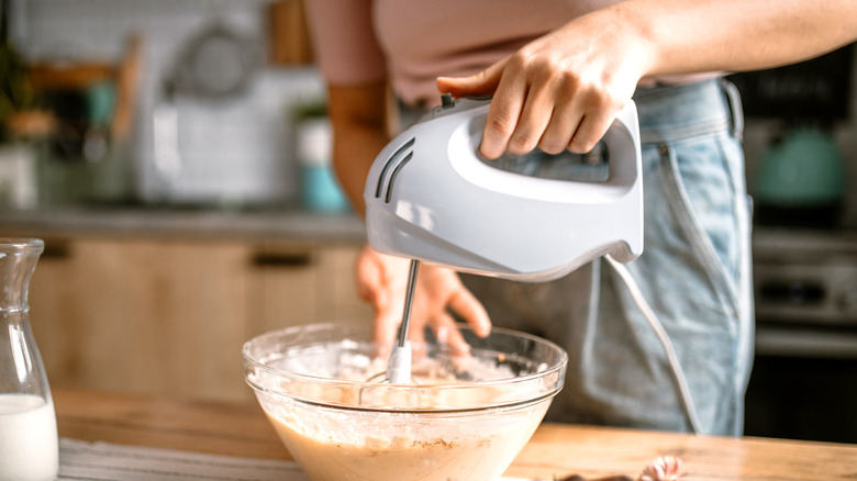 person using a handheld mixer