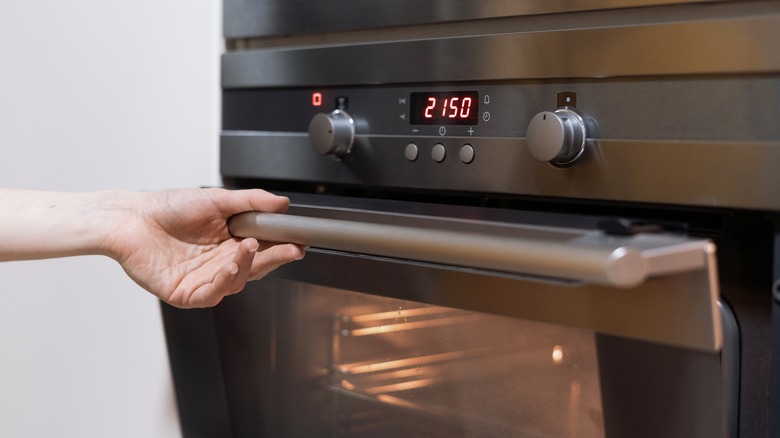 person opening oven door