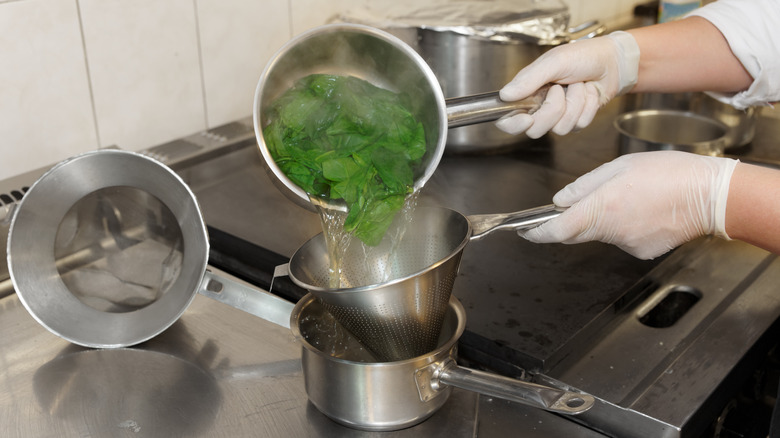 Chef blanching pot of spinach