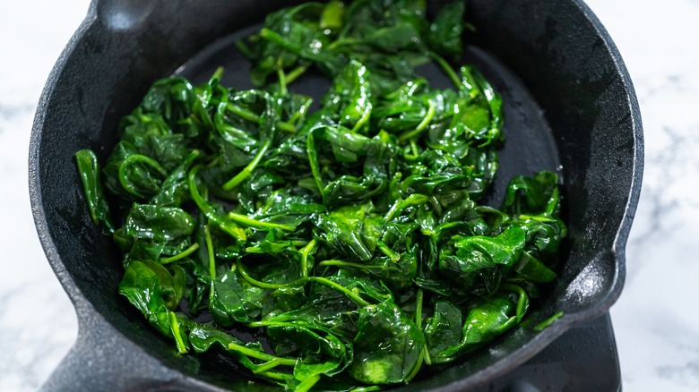 Skillet with cooked spinach