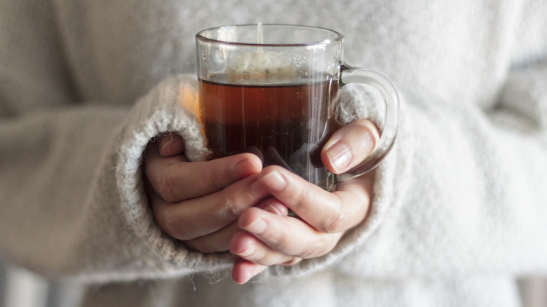 holding cup of tea