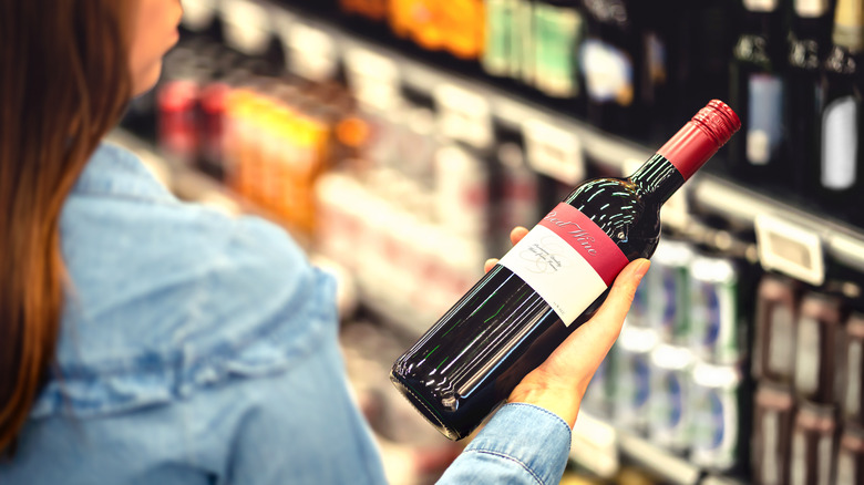 woman holding wine bottle at store