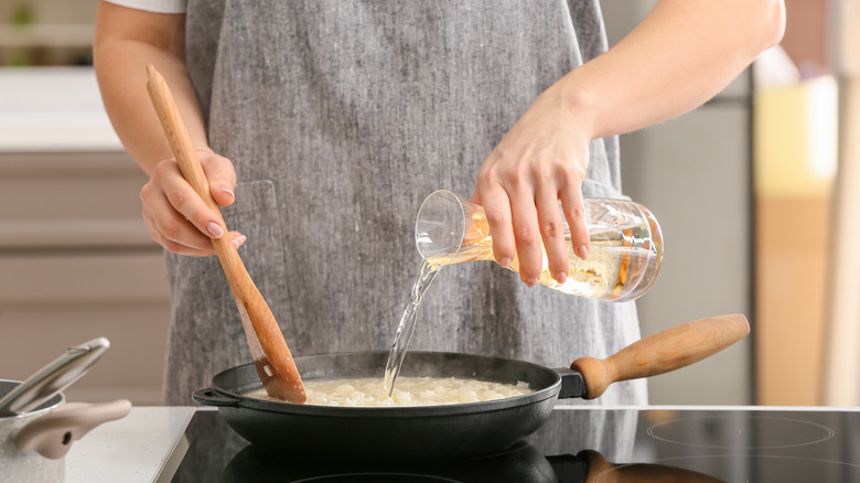 woman cooking in skillet with wine