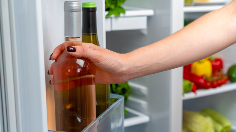 grabbing wine bottle from fridge