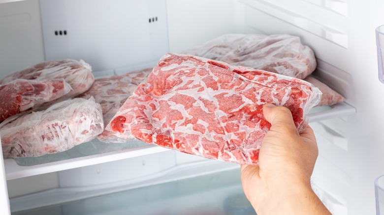 person holding frozen meat