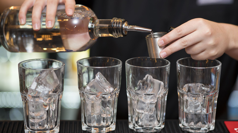 Bartender pouring liquid into glasses