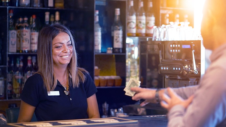 Person giving bartender cash