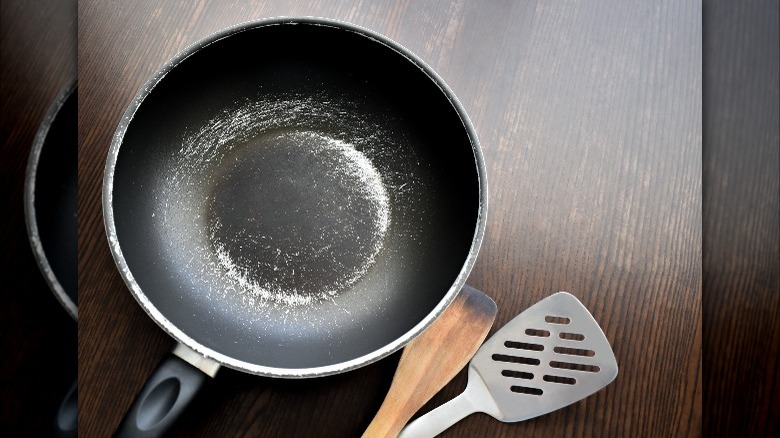 Metal spatula and scratched pan