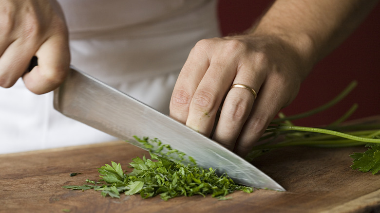 Chef dicing fresh parsley