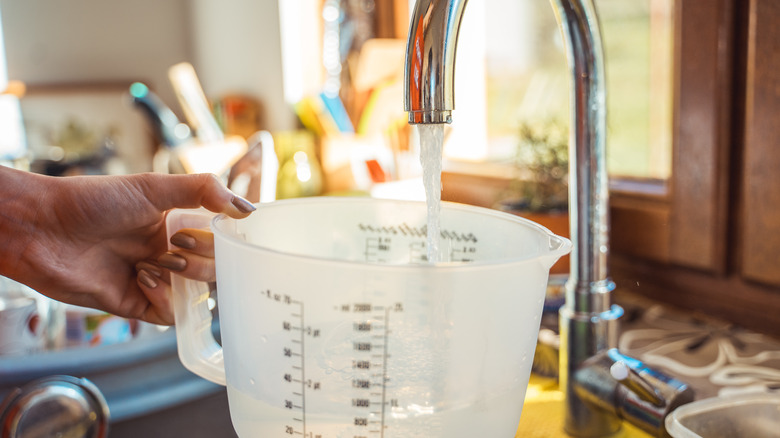 Filling measuring cup with water